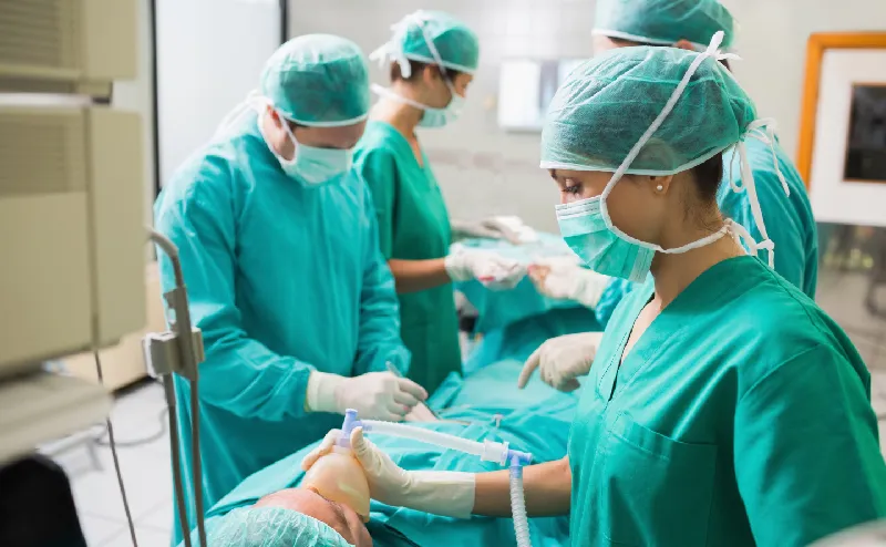 Total of four doctors and medical staff in green surgical gowns are performing a surgery. Mesh is also used for medical applications.