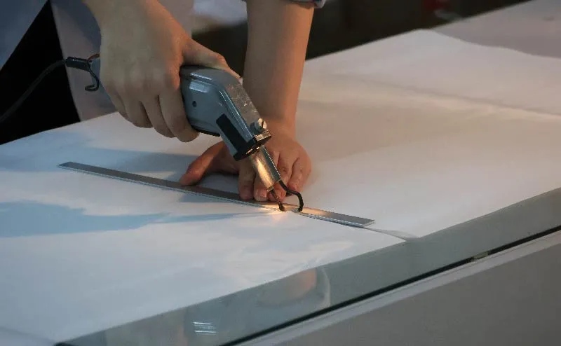 Close-up photo of hands performing mesh heat cutting work