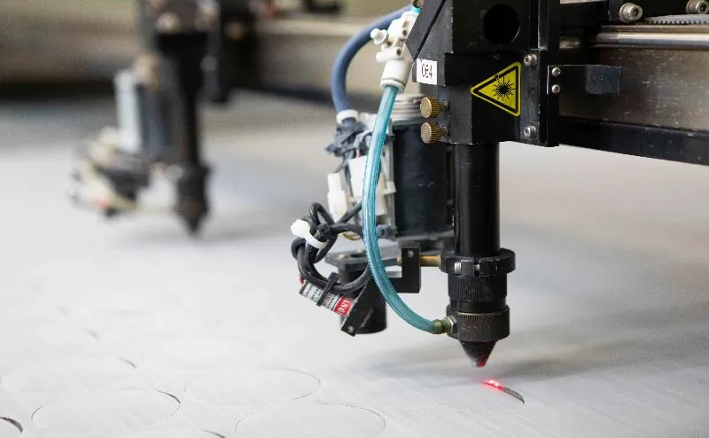 Photo of a laser cutting device cutting mesh cloth