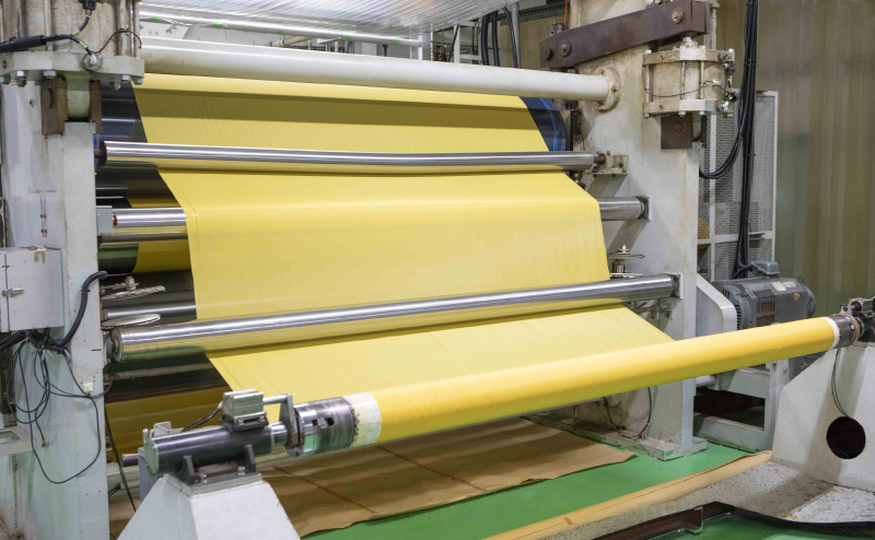 Photo of a calendar processing machine handling yellow mesh