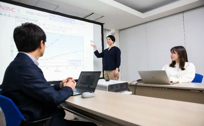 女性が2名に向けてプレゼンをする様子。