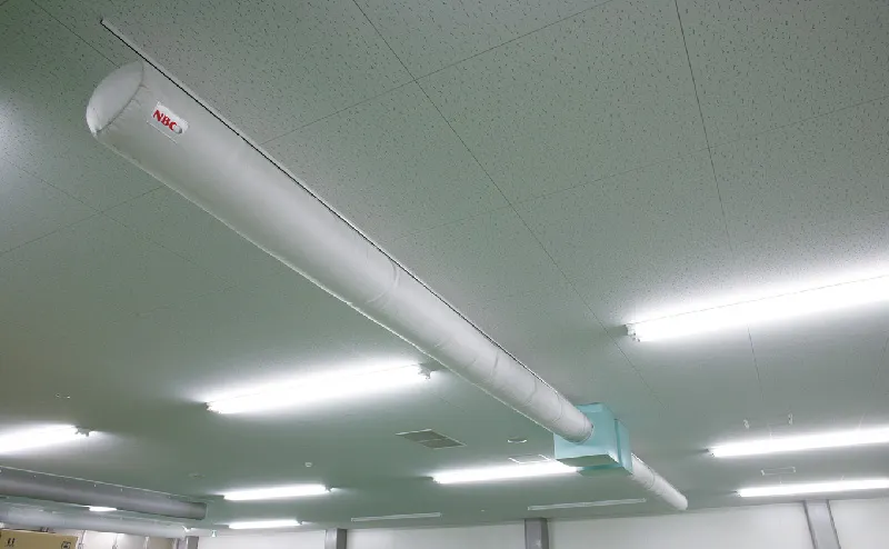 工場の天井に取り付けられている円筒状のメッシュクロス縫製品ソックダクトの写真