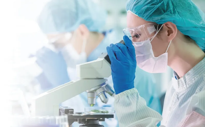 実験室で顕微鏡を使う科学者